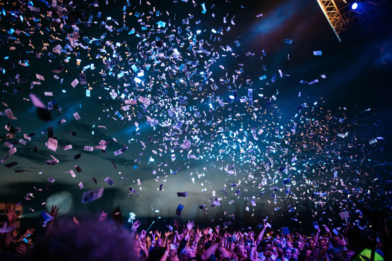 large group of people at a concert with confetti falling