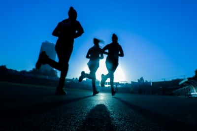 Three people running in silhouette