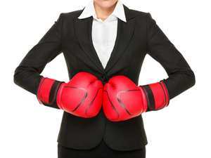 Woman at work with boxing gloves on to represent fighting-fit