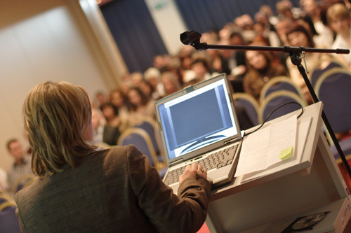 Woman presenting in front of a large crowd at an event