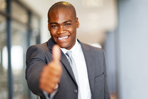 Happy man in office holding his thumb up