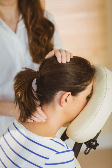 office massage job in london woman being given neck massage on blue massage chair up close