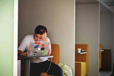 Stressed man alone on laptop