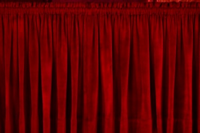 Thick red curtains, closed to block out any light